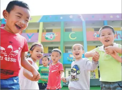  ?? PHOTOS BY SHAO RUI / XINHUA ?? Children play at a kindergart­en which was recently renovated as part of a poverty-relief program in Ankang, Shaanxi province.