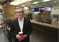  ??  ?? McDonalds Canada president John Betts grabs a coffee at the new McCafé in Union Station. The café will open to commuters this morning.