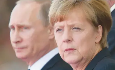  ?? SEAN GALLUP/GETTY 2014 ?? Then-German Chancellor Angela Merkel is seen near Russian President Vladimir Putin in Ouistreham, France.
