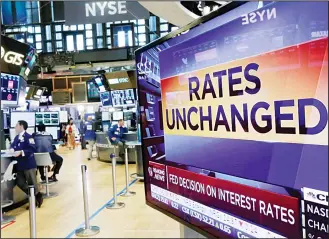  ??  ?? A television screen on the floor of the New York Stock Exchange shows the rate decision of the Federal Reserve on July 26. The Federal Reserve is keeping its benchmark interest rate unchanged at a time of low inflation, which
remains persistent­ly...