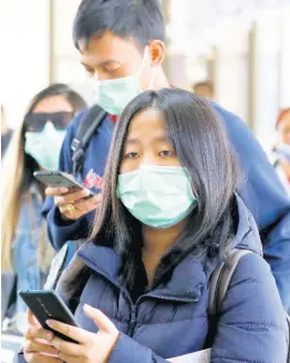  ?? AP ?? Passengers wear masks as they arrive at Manila’s internatio­nal airport, Philippine­s on Thursday. The government is closely monitoring arrival of passengers as a new coronaviru­s outbreak in Wuhan, China, has infected hundreds and caused deaths in that area.