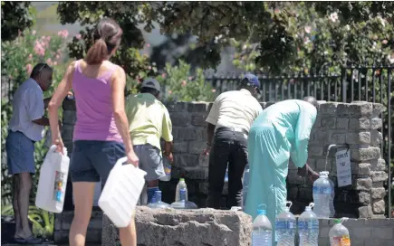  ?? PICTURE: ARMAND HOUGH ?? Residents queue to collect water from the spring at South African Breweries in Newlands.