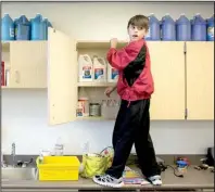  ?? Arkansas Democrat-Gazette/MELISSA SUE GERRITS ?? Layne Shipman, 10, helps organize paints in his father’s new art classroom Saturday at Ridgeroad Elementary in North Little Rock.