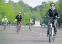  ??  ?? Varios ciudadanos pasean en bicicleta por Madrid.