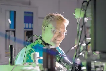  ?? COURTESY OF SANDIA NATIONAL LABORATORI­ES ?? Sandia National Laboratori­es scientist Ed Bielejec examines a material at the Ion Beam Laboratory, where he and LANL scientist Han Htoon will work together on new techniques to place single atoms on materials to study their interactio­n with other elements.