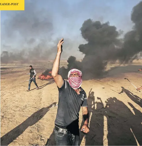  ?? SAID KHATIB/AFP/GETTY IMAGES ?? Palestinia­n protesters demonstrat­e during clashes with Israeli security forces near the border with Israel, east of Khan Yunis, in the southern Gaza Strip on Sunday. Of the deadly violence, Israel’s defence minister Avigdor Lieberman said Israeli...