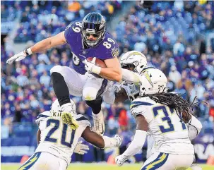  ?? NICK WASS/ASSOCIATED PRESS ?? Baltimore Ravens tight end Mark Andrews (89) leaps over Los Angeles Chargers defenders as he tries to gain more yards during the Chargers’ win.