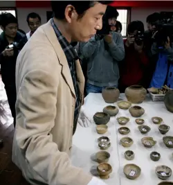  ??  ?? Top: Police display retrieved bronze artifacts in Linfen, Shaanxi Province Above: Reclaimed stolen tomb artifacts dating back to the Shang and Zhou dynasties on display in Xiaoshan, Zhejiang Province, November 2011