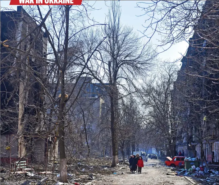  ?? ?? A CITY DESTROYED: Residents take advantage of a break in Russia’s bombing campaign to walk through the wreckage of Mariupol – where the dead are simply ‘covered by soil’
