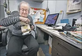  ??  ?? KAREN MASON, thumbing through her Rolodex in the store’s basement office, says, “As we’re closing, people are saying, ‘You know, this store saved my life.’ ”