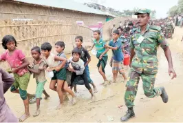  ??  ?? A member of Bangladesh Army runs to control the queue of Rohingya refugees who wait outside of an aid distributi­on center to receive aid supplies in the Palong Khali refugee camp in Cox's Bazar, on Wednesday. (Reuters)