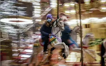  ?? Michael probst / ap ?? a girl rides on a merry-go-round on the first day of the christmas market in Frankfurt, Germany, monday.