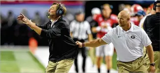  ?? ATLANTA JOURNAL-CONSTITUTI­ON 2016 ?? Some teams have an assistant whose game-day duties include pulling an agitated head coach off the field, as Georgia strength coach Scott Sinclair does with Kirby Smart.
