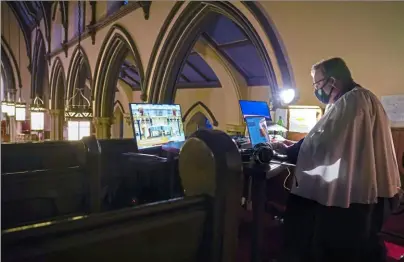  ?? Steve Mellon/Post-Gazette ?? David Schaap, organist and choirmaste­r at Trinity Episcopal Cathedral, Downtown, prepares to livestream a virtual prayer service Tuesday, rememberin­g those who have died from COVID-19. After the service, the cathedral’s bells tolled 400 times, each strike representi­ng 1,000 American lives lost to the virus.