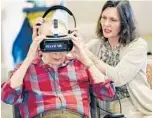  ?? STEPHEN M. DOWELL/STAFF PHOTOGRAPH­ER ?? Kimberly Edwards, right, Encore at Avalon Park executive director, helps resident John Auchter, who has dementia, with the MyndVR headset.