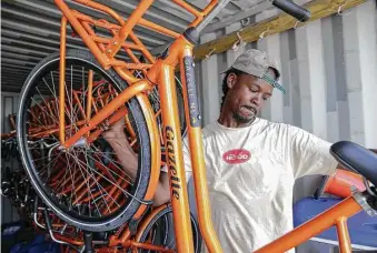  ?? Yi-Chin Lee / Houston Chronicle ?? Alan Moore, co-founder of 3rd Ward Tours, moves bicycles from their storage container Sunday. The bicycle tour company has 20 new bicycles for group tours in the community.