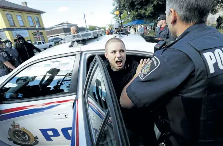  ?? CLIFFORD SKARSTEDT/EXAMINER FILES ?? City police escort William October to a city police cruiser on George St. during counter-protests to a planned white supremacis­t rally Sept. 30 in Confederat­ion Square.