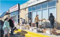  ??  ?? Staff and volunteers meet at the Delta Family Resource Centre distributi­on hub to portion and pack groceries for pickup and delivery to Rexdale families.