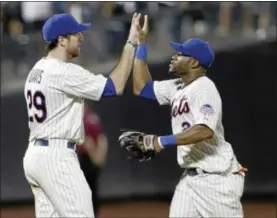  ?? FRANK FRANKLIN II — THE ASSOCIATED PRESS ?? New York Mets’ Ike Davis and Eric Young Jr. celebrate after their 4-1 win against the Atlanta Braves on Tuesday.