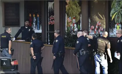  ??  ?? Police officers gather in front of law offices where a deadly shooting took place in Long Beach on Friday. Long Beach police on Friday called the shooting “workplace violence.” They said on Twitter that it has become a murder investigat­ion, and that...