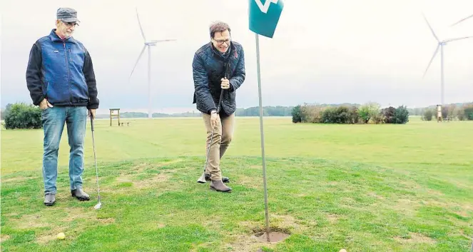  ?? BILDER: NWZ TV ?? Gar nicht so einfach: Ð -Chefredakt­eur Lars Reckermann (rechts) probiert sich auf seiner Tour durchs Oldenburge­r Land in Iserloy beim Swingolf aus. Bundesligi­st Uwe hilft ihm. Die „Lady’s“erreichte er trotzdem selten.