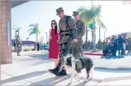  ?? Nelvin C. Cepeda
San Diego Union-Tribune ?? MARINE CAPT. Derek Herrera, shown with his wife, Maura, and his service dog, was able to walk at his Bronze Star ceremony using the ReWalk device.