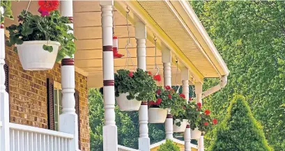  ?? DREAMSTIME ?? ,You don’t have to get fancy to spruce up your front porch. Keep the planters simple, but put dramatic plants in them.