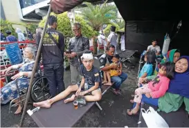  ?? (AFP) ?? Wounded people rest under a tent displayed outside a hospital following an earthquake in Cianjur on Monday