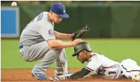  ?? MICHAEL CHOW/ THE REPUBLIC ?? The D-Backs’ Jarrod Dyson slides into second base for a double ahead of the tag by Dodgers shortstop Corey Seager during the first inning on Wednesday at Chase Field.