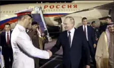  ?? Konstantin Zavrazhin, Sputnik, Kremlin Pool Photo via AP ?? Russian President Vladimir Putin shakes hands with an officer upon his arrival at an internatio­nal airport in Riyadh, Saudi Arabia, on Wednesday.