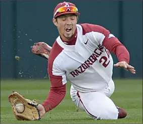  ?? NWA Democrat-Gazette/ANDY SHUPE ?? Arkansas center fielder Dominic Fletcher grabs a ball off the bounce to hold Auburn to a single during Friday’s game.