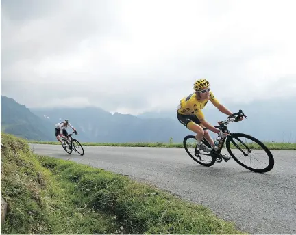  ?? CHRISTOPHE ENA / THE ASSOCIATED PRESS ?? Britain’s Geraint Thomas, wearing the yellow jersey, is followed by teammate Britain’s Chris Froome as they speed down Col de Val Louron-Azet pass Wednesday during the 17 th stage of the Tour de France.