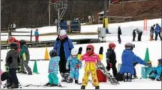  ?? PHOTOS BY MICHILEA PATTERSON — DIGITAL FIRST MEDIA ?? A young girl waves and smiles as she takes snowboardi­ng lessons at Spring Mountain Ski Area in Upper Salford.