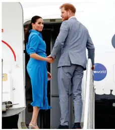  ??  ?? Relaxed: Meghan and Harry board the flight in Tonga