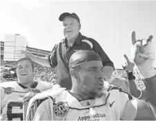  ?? FILE PHOTO BY DUANE BURLESON, AP ?? Appalachia­n State and then- coach Jerry Moore enjoy a 2007 upset of Michigan that aired on upstart Big Ten Network.