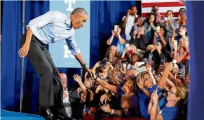  ??  ?? Big welcome: Obama reacting as he is almost pulled off the catwalk by a supporter as he arrives to speak at a rally in Las Vegas. — Reuters