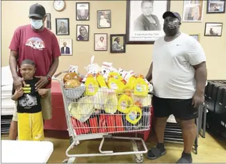  ?? Submitted Photo ?? Lamar and Haston Cole give back to the St. Francis County Food Pantry in honor of his mother and LaTwon Whitby’s mother-in-law, Floyda Williams, who once served as a Pantry volunteer. Whitby said, "It’s a blessing to continue her legacy and knowing this donation will help so many within our community."