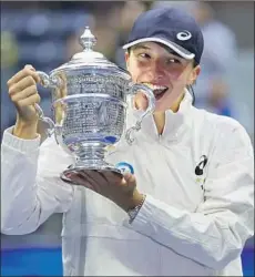  ?? Matt Rourke Associated Press ?? IGA SWIATEK poses with the championsh­ip trophy after beating Ons Jabeur 6-2, 7-6 (5) in the U.S. Open women’s singles final.