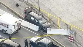  ?? PHOTO BY WUSA TV-9 VIA AP ?? Authoritie­s investigat­e the scene of a shooting at Fort Meade, Md.b on Wednesday. A suspect has been held, taken from the black SUV that stopped at a barrier after a shooting outside the National Security Agency.