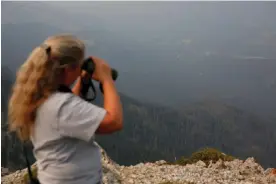  ?? Photograph: Brittany Hosea-Small/Reuters ?? Samsara Duffey, 45, looks out from the Patrol Mountain Fire Lookout in Augusta, Montana, on 16 July 2021.