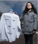  ?? M. MCCARTHY WATERLOO REGION RECORD ?? Lupita Guerrero, holds her embroidere­d shirt called “We Regret To Inform You.”
