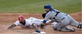  ?? Getty IMaGes ?? JUST IN THERE: Washington’s Eric Thames just beats the tag of Blue Jays catcher Danny Jansen in the fourth inning Monday.