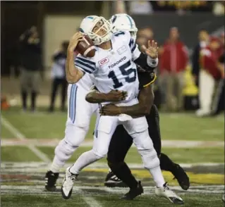  ?? PETER POWER, THE CANADIAN PRESS ?? Toronto quarterbac­k Ricky Ray is sacked from behind by defensive end Adrian Tracy.