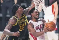  ?? MARK J. TERRILL— THE ASSOCIATED PRESS ?? Heat forward Jimmy Butler drives to the basket past Lakers center Dwight Howard during the first half of Game 5of the NBA Finals on Oct. 9in Lake Buena Vista, Fla.