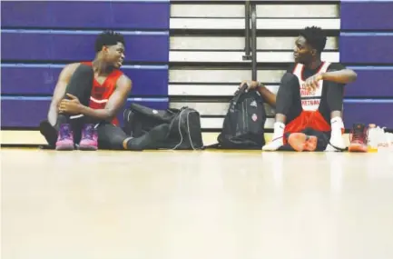  ??  ?? Assane Diouf, left, and Samba Kane relax after practice last week with the Colorado Hawks, a Denver-area AAU basketball team. Diouf and Kane are gentle giants who came to the U.S. from Senegal.