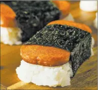  ??  ?? Thinkstock Sauteed Spam with sushi rice wrapped in nori, or Spam musubi, originated in Hawaii.