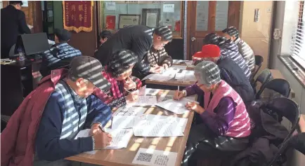  ??  ?? Senior citizens write their wills at a center that offers free legal aid in Beijing.