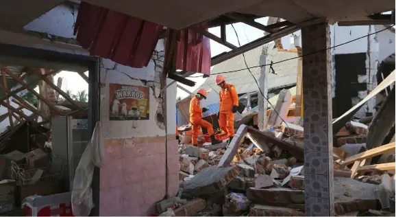  ??  ?? Rescue teams search for victims in the rubble caused by the earthquake in North Lombok, Indonesia,