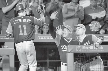  ?? Harry How Getty Images ?? DODGERS MANAGER Dave Roberts is the first to greet Logan Forsythe, a.k.a. “Logie Bear,” after his home run in the fourth inning.