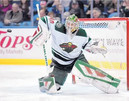  ?? GARY WIEPERT/THE ASSOCIATED PRESS ?? Minnesota goalie Devan Dubnyk reaches out with his blocker pad to fend off a shot against Buffalo on Saturday en route to the Wild winning its fourth straight game.